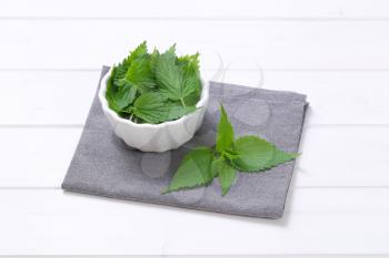 bowl of fresh nettle leaves on grey place mat
