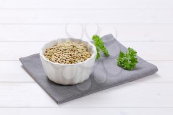 bowl of dry brown lentils on grey place mat