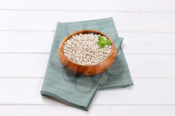 bowl of raw white beans on grey place mat