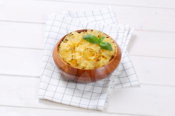 bowl of quadretti - square shaped pasta on checkered dishtowel