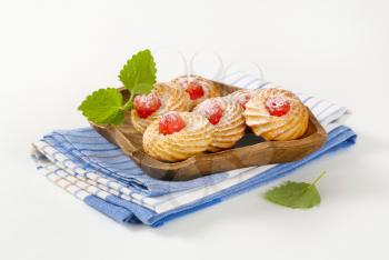Traditional Sicilian almond cookies topped with glace cherries and sprinkled with powdered sugar