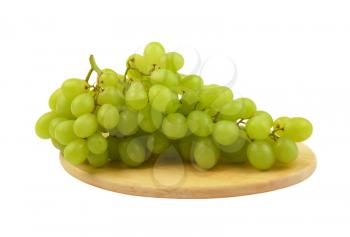 bunch of white grapes on round wooden cutting board