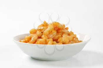 Bowl of cooked peeled shrimps with spicy sauce