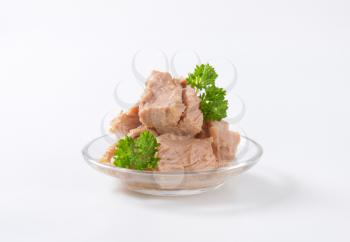 bowl of canned tuna with parsley on white background