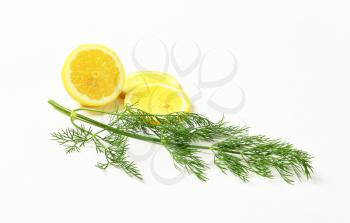 Fresh dill weed and lemon slices on white background