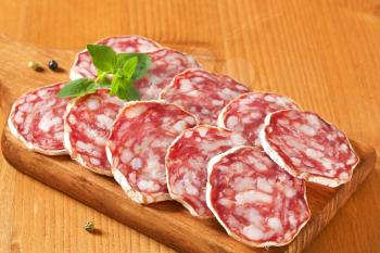 Sliced French dry sausage (Saucisson Sec)  on cutting board