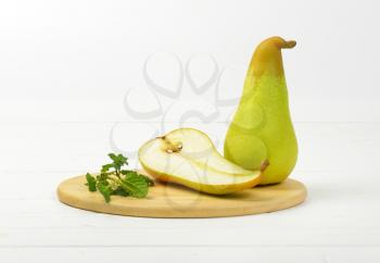 one and half pears on round wooden cutting board