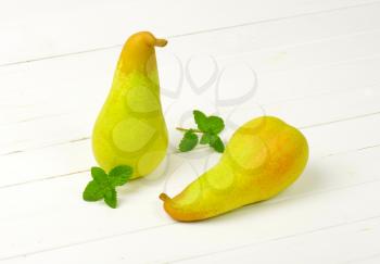 two yellow pears on white wooden background