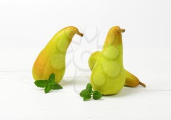 three yellow pears on white wooden background