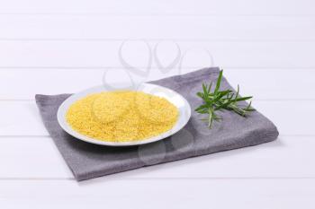 plate of raw millet on grey place mat