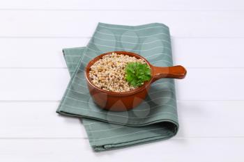 saucepan of cooked pearl barley on grey place mat