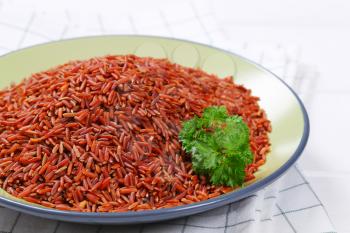 plate of red rice on checkered dishtowel - close up