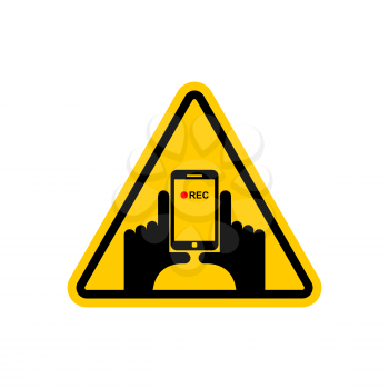 Attention Vertical video. Hand and smartphone to record. Road sign on yellow triangle. symbol Caution