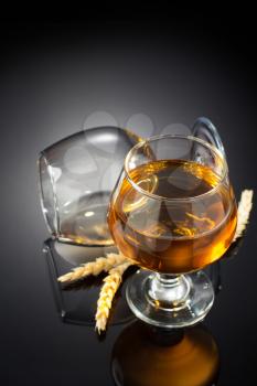 cognac and  glass on black background