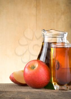 apple juice in glass and slices on wood background