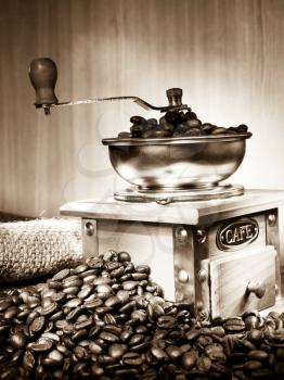 coffee grinder and beans and pot on sacking on sepia