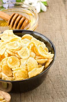 bowl of corn flakes and nutrition on wooden background