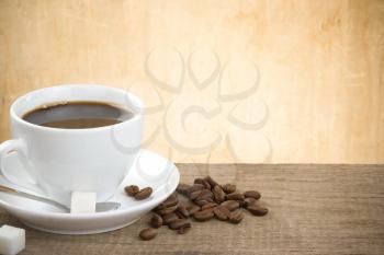 cup of coffee and roasted beans on wood background table
