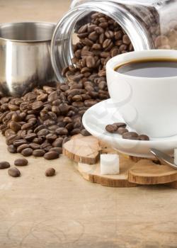 cup of coffee and pot with roasted beans