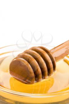 honey in glass and stick isolated on white background