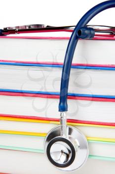 pile of books and stethoscope isolated on white background