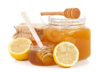 pot of honey and sliced lemon on white