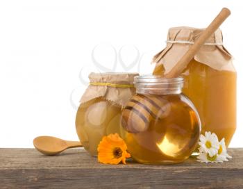 honey in jar isolated on white background at old wood wood