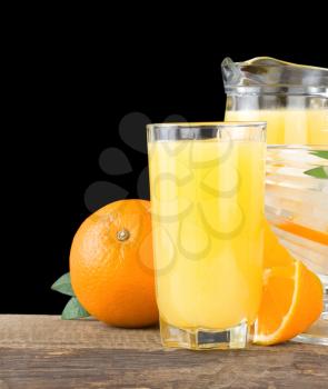orange fresh fruits and juice in glass isolated on black background