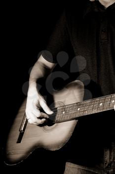 man playing guitar at black background