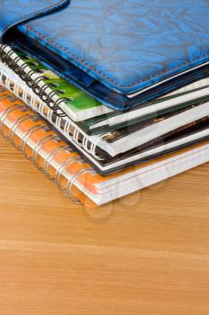 pile of books and notebook on wood background texture