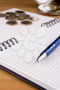 pen and coin on notebook