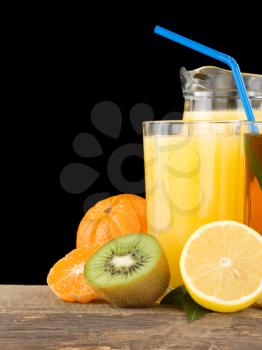 fresh fruits and juice in glass isolated on black background