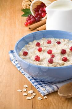 bowl of oatmeal and milk on wood background