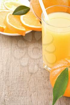 orange juice and fruit on wood background