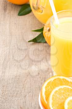 orange juice and glass on wood background