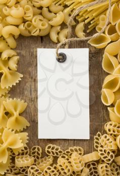raw pasta and price tag on wood as background