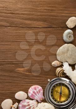 seashell and compass on wood background