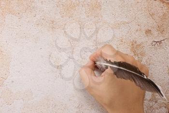 writing male hand with feather on background
