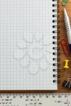 notebook and office accessories on wood background