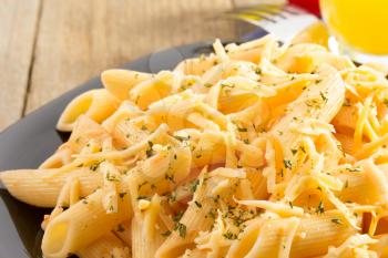 pasta Penne in plate on wooden background