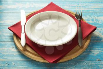 plate, knife and fork on rustic wooden background