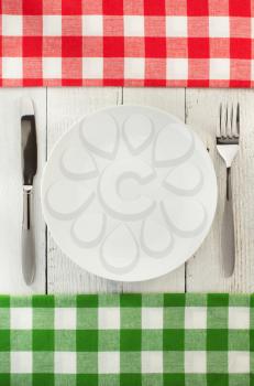 cloth napkin and plate on wooden background