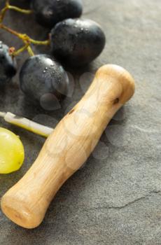 corkscrew and grape on table