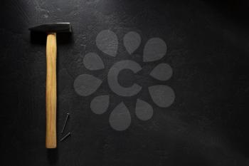 hammer tool and nail at black  background