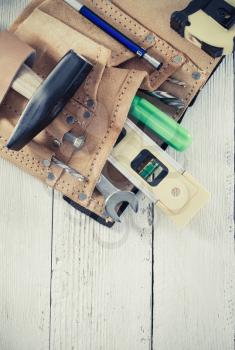 tools and instruments in belt on wooden background