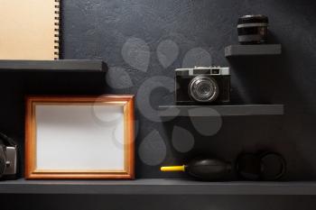 old camera and picture at wooden shelf