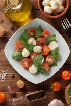 caprese salad and ingredients at wooden  background
