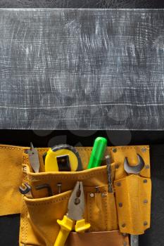 tools and instruments in belt on black background