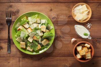 caesar salad and ingredients at wooden  background