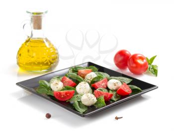 basil, mozzarella and tomato salad isolated on white background